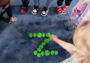 Dzieci układające literkę "Z" na dywanie