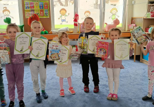 Dzieci prezentujące swoje dyplomy i nagrody