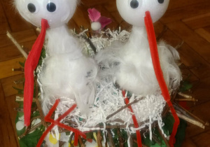 Kapelusz wiosenny przedstawiający dwa bociany w gnieździe