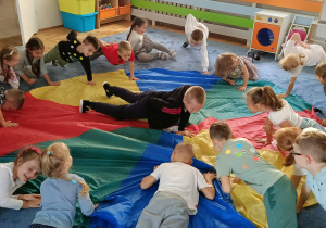 dzieci siedzące w okręgu wykonują ćwiczenia związane z kropką