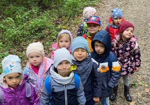 Zdjęcie przedstawia dzieci na wycieczce w lesie