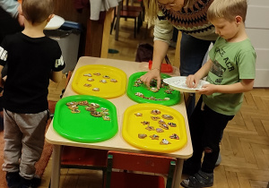 Zdjęcie przedstawia dzieci dekorujące pierniki