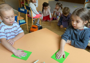Zdjęcie przedstawia dzieci które robią kartkę świateczną