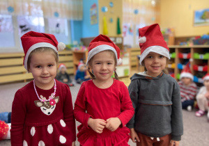 Zdjęcie przedstawia dzieci w czapkach Mikołajów