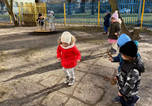 Zdjęcie przedstawia dzieci w ogrodzie przedszkolnym