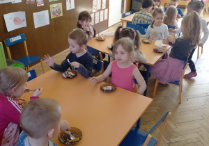 Zdjęcie przedstawia dzieci, które jedzą tort