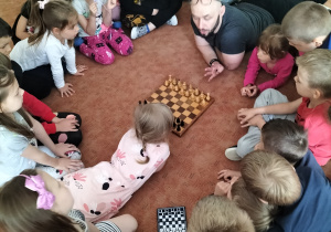 Zdjęcie przedstawia dzieci w trakcie warsztatów szachowych