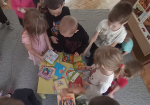 Zdjęcie przedstawia dzieci w trakcie czytania książek
