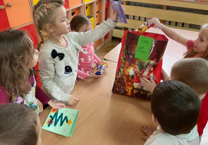 Zdjecie przedstawia dzieci pakujące dary dla DPS