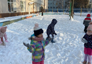 Zdjęcie przedstawia dzieci w trakcie zabaw na śniegu