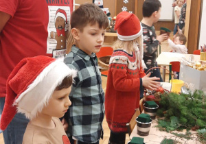 Zdjęcie przedstawia dzieci oraz rodziców podczas warsztatów ozdób świątecznych
