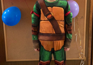 Zdjęcie przedstawia chłopca przebranego za żółwia ninja