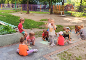 Zdjęcie przedstawia dzieci bawiące się na dworze