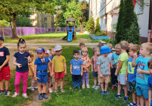 Zdjęcie przedstawia dzieci w trakcie koncertu w ogrodzie