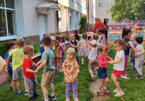 Zdjęcie przedstawia dzieci w trakcie koncertu w ogrodzie